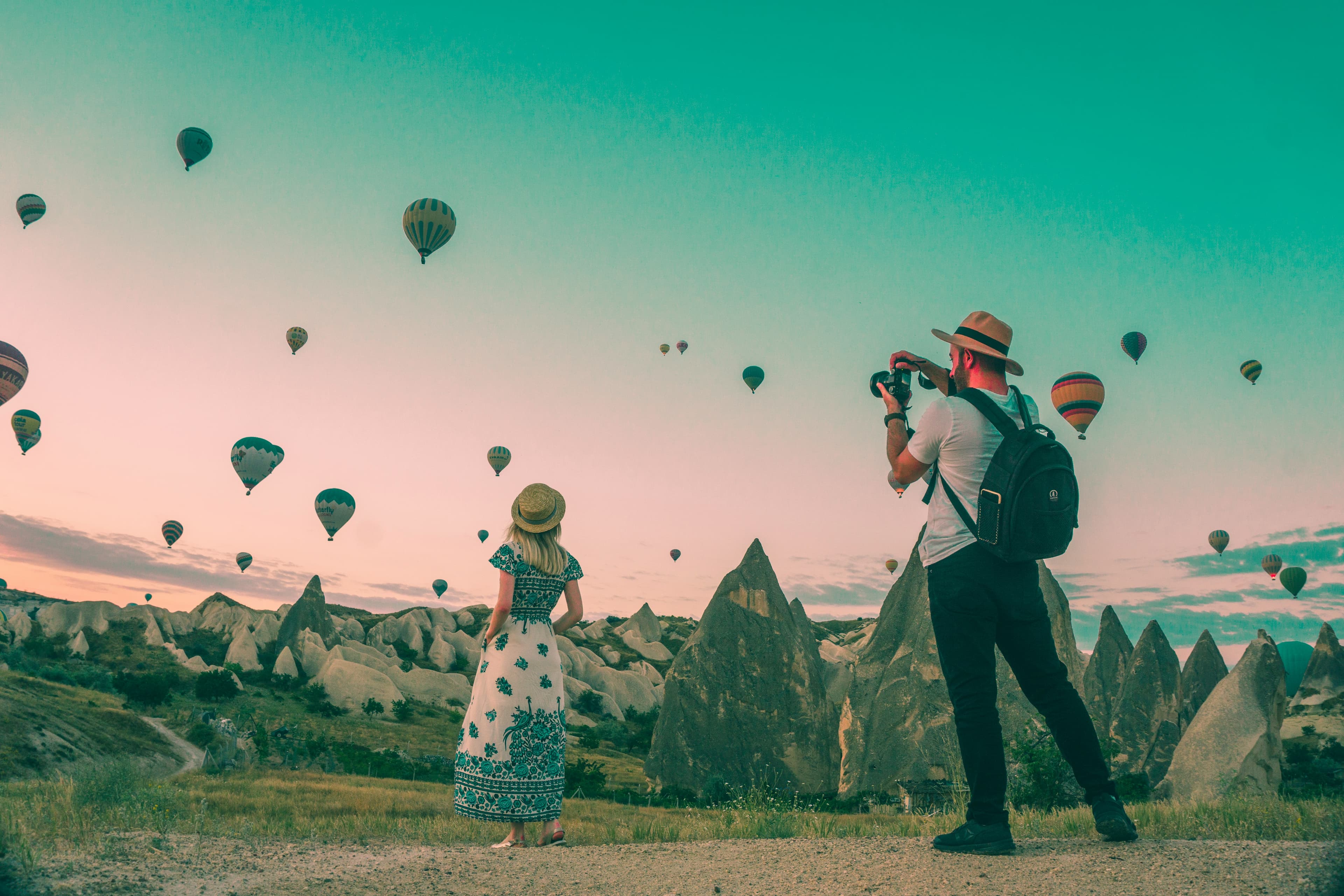 Travelers watching hot air balloons at sunrise in Cappadocia